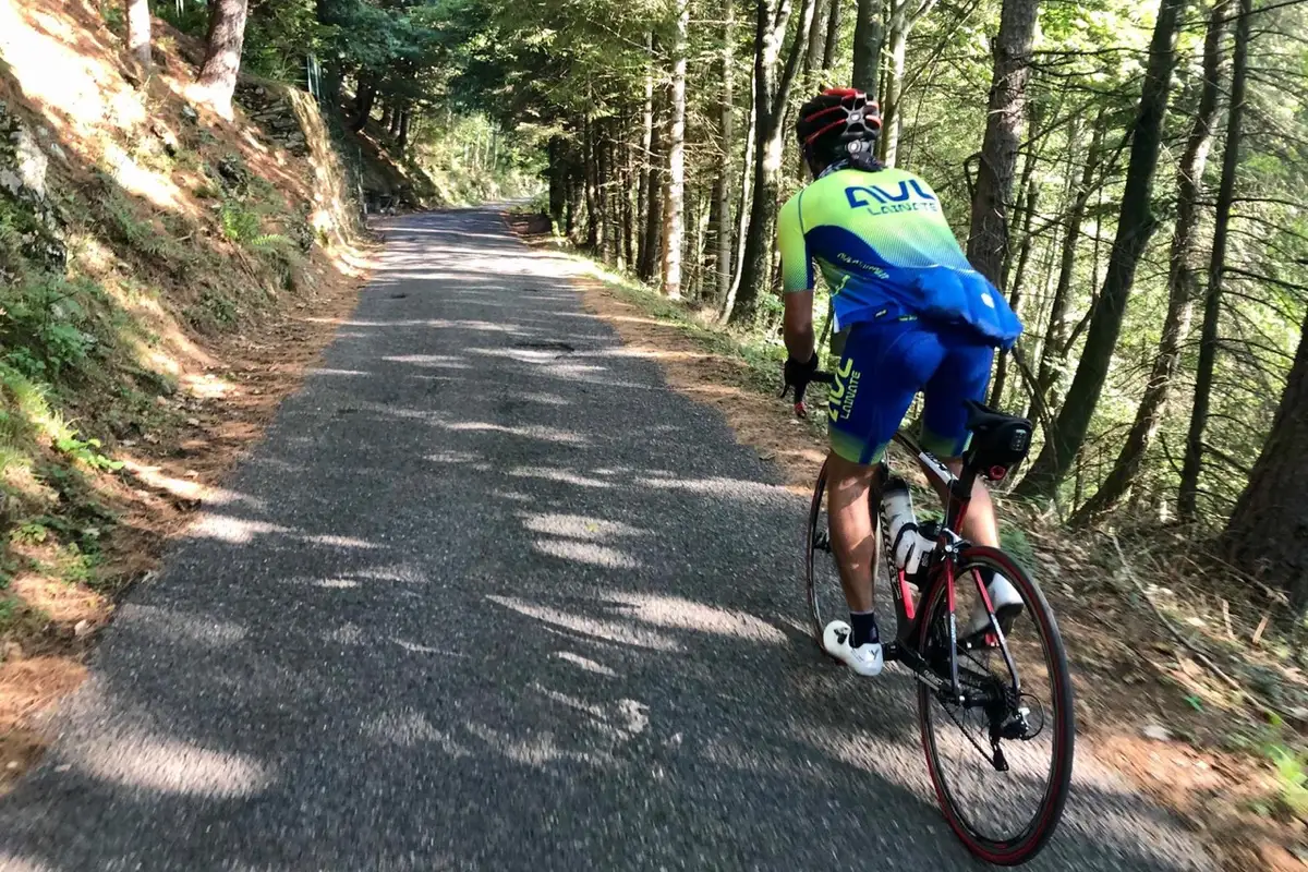 Un ciclista pedala tra le salite e il bosco