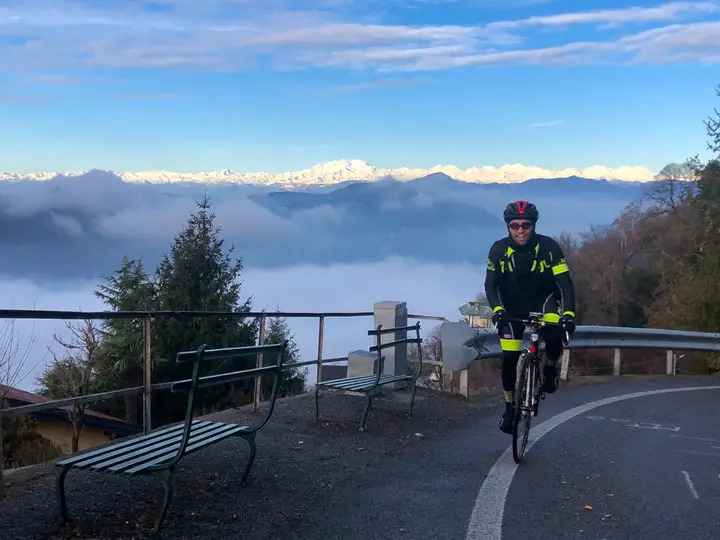 Un ciclista e un panorama di montagne sopra le nuvole