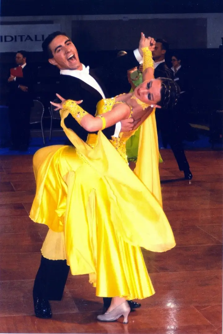 Un momento di gara di danza sportiva con abito giallo