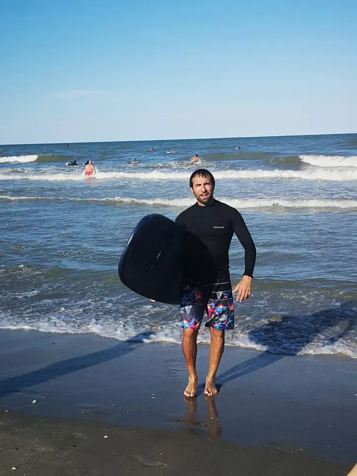 Francesco in riva al mare con la tavola da surf